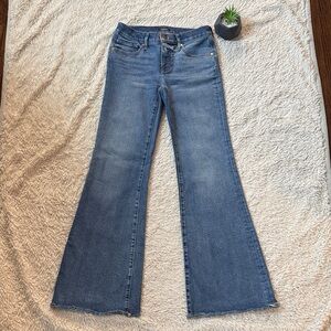 Express '70s Flare Low Rise Jeans in a medium wash with a raw hem.  Size 4R